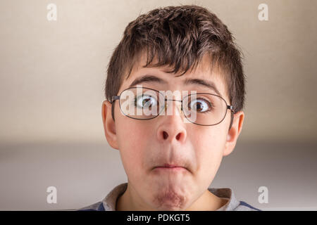 Boy saugt Wangen und drückt seine Lippen, die sonderbaren Gesicht als Zeichen der Überraschung Stockfoto