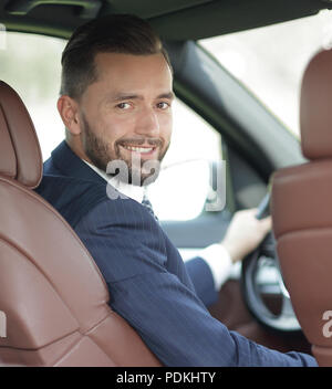 Unternehmer sitzen am Steuer eines Autos, und wenn man die Kamera Stockfoto