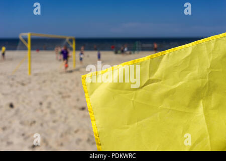 Gelbe Fahne mit Sand auf dem Fußballfeld am Meer am Strand Stockfoto