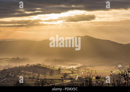 Sonnenstrahlen kommen über ein Tal in Umbrien (Italien) Stockfoto