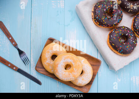 Frühstück Konzept: Donut auf Platte mit Messer und Gabel auf hölzernen Hintergrund Stockfoto