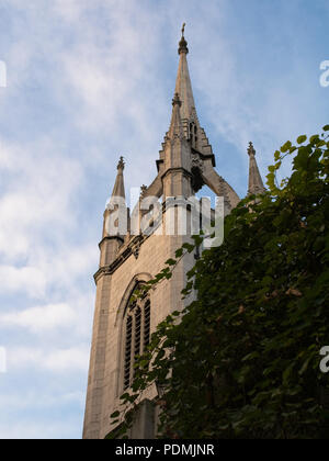 Low Angle View der Kirchturm in St. Dunstan im Osten. Großer Baum im Vordergrund, blauer Himmel und Wolken im Hintergrund. Stockfoto