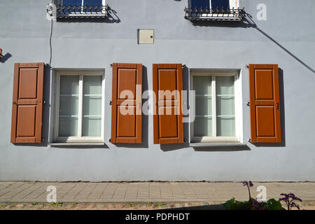 Fenster mit Fensterläden auf einer kleinen Straße in Vilnius Stockfoto