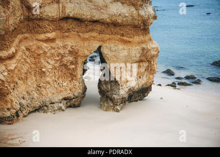 Ein Felsen mit einer Felsspalte am Strand in der Stadt Lagos in Portugal genannt. In der Nähe des Atlantik. Stockfoto