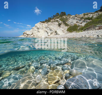 Bucht an der felsigen Küste mit Steinen und Felsen unter Wasser, geteilte Ansicht oberhalb und unterhalb der Oberfläche, Mittelmeer, Costa Blanca, Javea, Valencia, Spanien Stockfoto