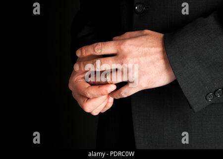 Untreue Konzept. Reifer Mann aus seinem goldenen Ehering, close-up auf Händen Stockfoto