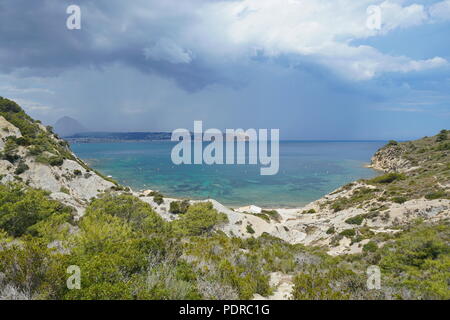 Spanien Javea Bucht Cala Sardinera mit stürmischen Himmel und dem Kap San Antonio im Hintergrund, Mittelmeer, Costa Blanca, Alicante, Valencia Stockfoto