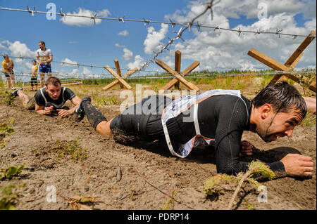 In Tjumen, Russland - Juli 1, 2017: Rennen der Helden Projekt auf dem Boden der höchsten militärischen und technischen Schule. Leute, die unter einem Stacheldraht Stockfoto