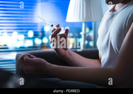 Drogensüchtigen heroin Nadel in der Hand halten. Junger Mann mit Injektionsspritzen. Dramatische sucht, Überdosierung und narkotischen Missbrauch Konzept. Stockfoto