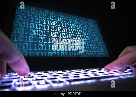 Hacker schreiben Virus Code mit Laptop im Dunkel. Daten crimimal im Schatten. Cyber Security, Internet Betrug und Phishing Konzept. In der Nähe der Hände. Stockfoto