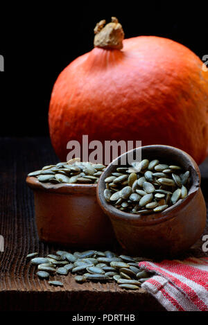 Kuerbiskerne in Keramiktoepfen, Cucurbita spec. Stockfoto