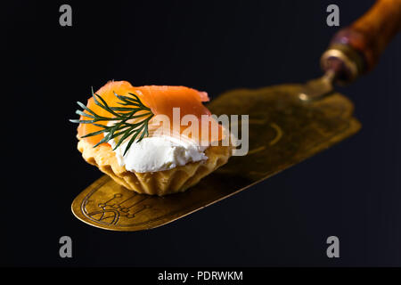 Kanapees mit geräuchertem Lachs oder Forelle, Frischkäse und Dill. Leckerer Snack. Fisch und Meeresfrüchte. Stockfoto