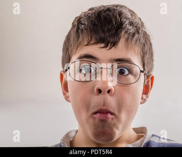 Boy saugt Wangen und drückt seine Lippen, die sonderbaren Gesicht als Zeichen der Überraschung Stockfoto