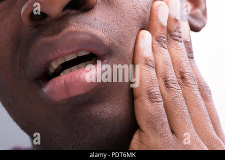 Nahaufnahme eines Mannes mit Zahnschmerzen vor weißem Hintergrund Stockfoto