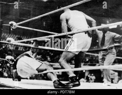 243 StateLibQld 1 175511 Boxer, Adrian Holmes, klopft ein Gegner auf die Matte bei den Olympischen Spielen in London 1948. Stockfoto