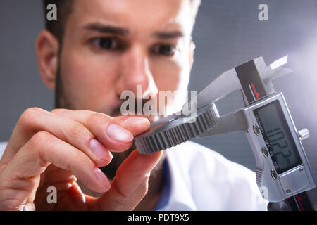 Close-up von der Größe eines Menschen Hand Messgetriebe mit digitalen elektronischen Messschieber Stockfoto