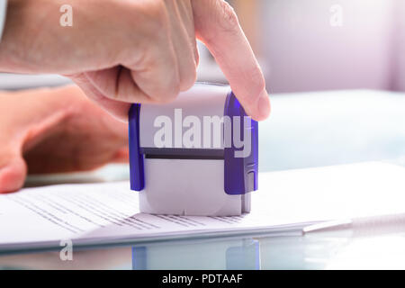 In der Nähe von einem Geschäftsmann Hand Stanzen Genehmigt auf Dokument Stockfoto