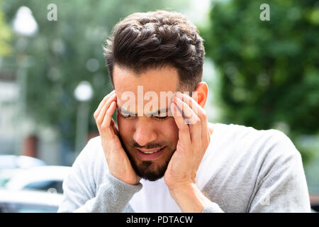 Nahaufnahme eines jungen Mannes leiden unter Kopfschmerzen. Stockfoto