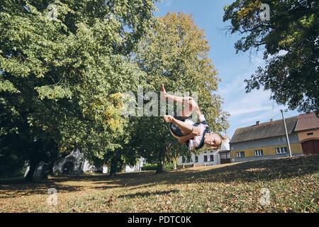 Junge üben sich runnuing in öffentlichen Parks und auf den Kopf springen. Stockfoto