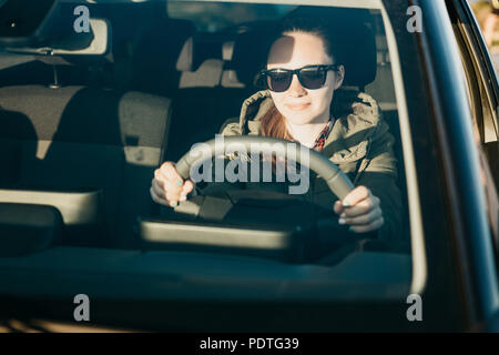 Portrait einer jungen lächelnd fröhliche Frau oder ein Mädchen Fahrer im Auto. Tagesausflüge auf den Verkehr oder Tourismus, Straßenfahrt oder Abenteuer. Stockfoto