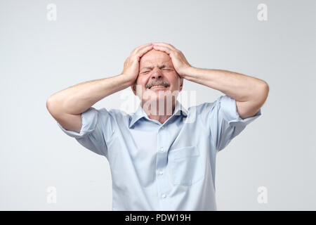 Kaukasische älterer Mann, der schreckliche Kopfschmerzen. Problem mit der Gesundheit im Alter Stockfoto