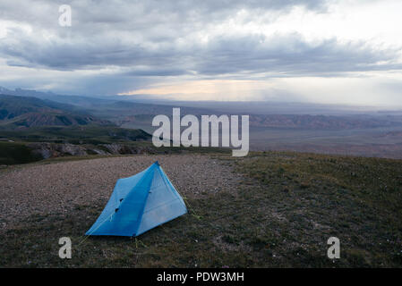 Camping mit einem kleinen blauen Zelt im Tian Sham Berge, Kirgisistan. Tian Shan Gebirge sind einige der besten Plätze, um Wandern zu gehen. Stockfoto