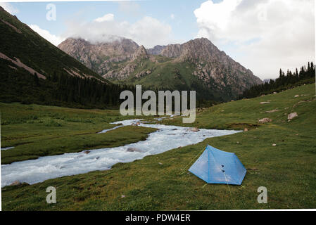 Camping mit einem kleinen blauen Zelt im Tian Sham Berge, Kirgisistan. Tian Shan Gebirge sind einige der besten Plätze, um Wandern zu gehen. Stockfoto