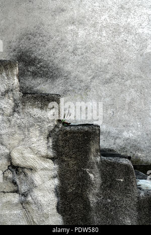 Freistehende alte rustikalem Stein Treppe nach oben mit einem Haus aus Stein vorn hinter Stockfoto