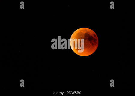 Vollmond oder Blut Mond während einer vollständigen Mondfinsternis in einem schwarzen Nachthimmel mit Sternen Stockfoto