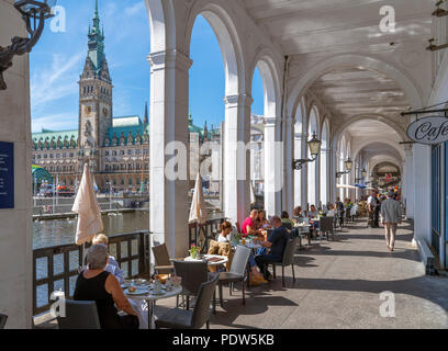 Hamburg, Deutschland. Cafe mit Blick auf das Rathaus (Rathaus) von den Alsterarkaden auf der Kleinen Alster, Hamburg, Deutschland Stockfoto