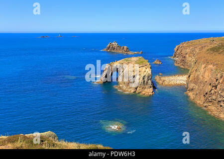 Enys arch Dodnan, bewaffneten Ritter Meer stack und fernen Longships Leuchtturm von der South West Coast Path, Sennen, Lands End, Cornwall, England, Großbritannien. Stockfoto