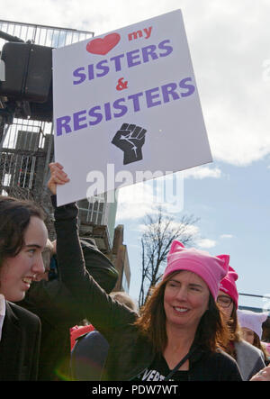 Asheville, NC, USA - Januar 20, 2018: Junge Frau trägt einen pussyhat im März 2018 der Frauen trägt ein Schild mit der Aufschrift "meine Schwestern und Resisters' Stockfoto