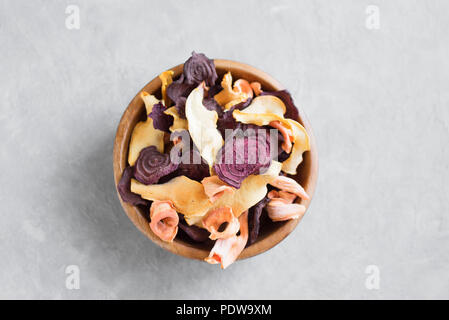 Verschiedenen pflanzlichen Chips auf grauem Hintergrund, kopieren. Verschiedene getrocknete rote Beete, Karotten, Kürbis Gemüse Chips - gesunden veganen Snack. Stockfoto