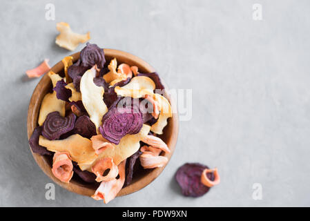 Verschiedenen pflanzlichen Chips auf grauem Hintergrund, kopieren. Verschiedene getrocknete rote Beete, Karotten, Kürbis Gemüse Chips - gesunden veganen Snack. Stockfoto