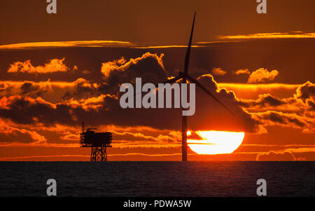 Sonnenuntergang über eine Turbine und der Unterstation auf Walney Erweiterung Offshore-windpark Stockfoto