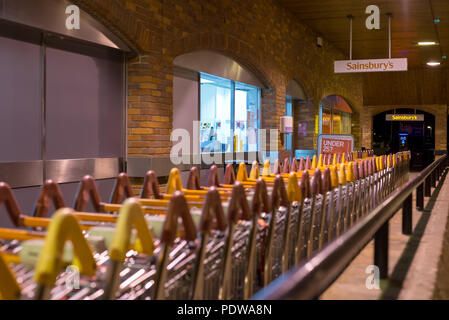 Sainsbury's Supermarkt Eingang, die maltings, Salisbury, Wiltshire, England bei Nacht mit Supermarkt Trolleys Stockfoto