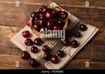 Cherry in der Schüssel auf einem hölzernen Hintergrund Stockfoto