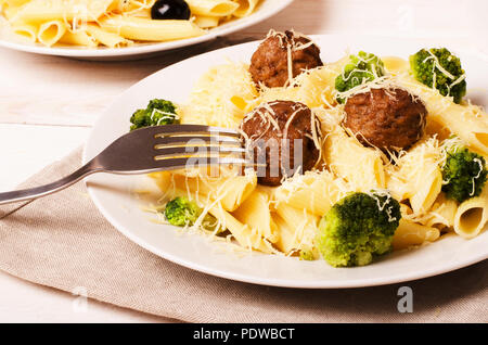 Pasta Penne mit Frikadellen und Brokkoli mit Gabel auf einem Teller Stockfoto