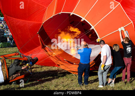 Gasbrenner von Hot Air Balloon brennen Ballonhülle aufblasen. Ricoh Cube Ballon G-RCOH von Cameron Balloons gebaut. Bodenpersonal. Team Stockfoto