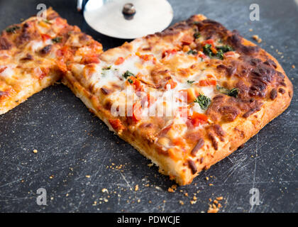 Quadratische Scheiben köstliche italienische Pizza Margarita an Bord mit Schneidevorrichtung Stockfoto