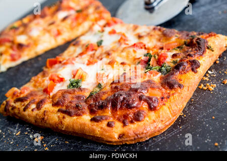 Quadratische Scheiben köstliche italienische Pizza Margarita an Bord mit Schneidevorrichtung Stockfoto