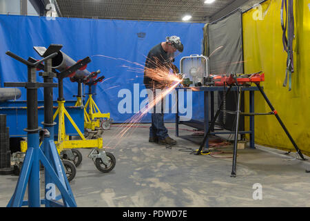 Mann bei der Arbeit mit Metall Rohre schleifen Stockfoto