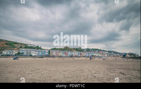 Sommer Sandstrand und bunte Gebäude der Küstenstadt Anglesey in Wales, Großbritannien Stockfoto