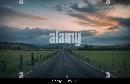 Leere lange aspahlt Straße und Dämmerung Himmel in Gwynedd, Wales, Großbritannien Stockfoto