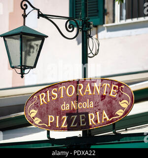 PORTOFINO, ITALIEN - 19. MAI 2018: Schild für Pizzeria Restaurant und Vintage Lampe Stockfoto