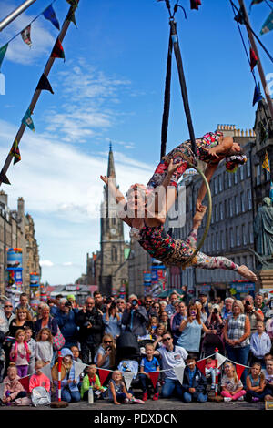 Edinburgh, Schottland, Großbritannien, 10. August 2018, Edinburgh Fringe Festival auf der Royal Mile, Antenne Trapezkünstlern schlangenmenschen das Publikum in der Sonne unterhalten. Stockfoto