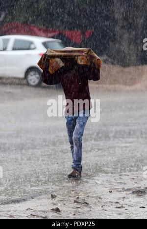 Allahabad, Uttar Pradesh, Indien. 11 Aug, 2018. Allahabad: eine Jugend decken sich mit colthe bei Regen in Allahabad am 11-08-2018. Credit: Prabhat Kumar Verma/ZUMA Draht/Alamy leben Nachrichten Stockfoto