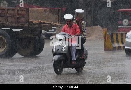 Allahabad, Uttar Pradesh, Indien. 11 Aug, 2018. Allahabad: Pendler Fahren bei Regen scooty in Allahabad am 11-08-2018. Credit: Prabhat Kumar Verma/ZUMA Draht/Alamy leben Nachrichten Stockfoto