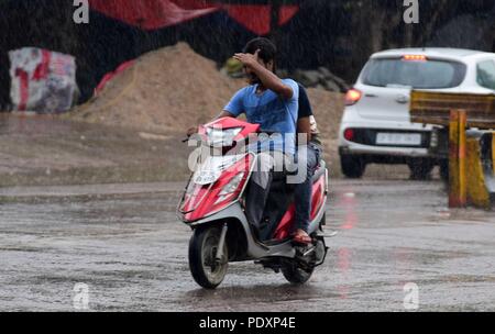 Allahabad, Uttar Pradesh, Indien. 11 Aug, 2018. Allahabad: Pendler Fahren bei Regen scooty in Allahabad am 11-08-2018. Credit: Prabhat Kumar Verma/ZUMA Draht/Alamy leben Nachrichten Stockfoto