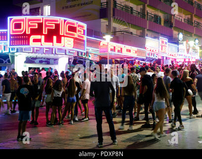 Calvia, Spanien. 11 Aug, 2018. Junge Menschen stehen vor Bars und Diskotheken auf der Straße zu rauchen und Chat. Magaluf ist eines der wichtigsten Reiseziele für britische Touristen in der Sommersaison auf der Balearen Insel Mallorca in Spanien. Die beliebten Punta Balena Streifen in Magaluf ist die Heimat der meisten Nachtclubs und Bars, die fast ausschließlich auf die Britischen Rauschtrinken Tourismus mit extrem niedrigen Alkoholgehalt und Fast Food. Credit: Clara Margais/dpa/Alamy leben Nachrichten Stockfoto